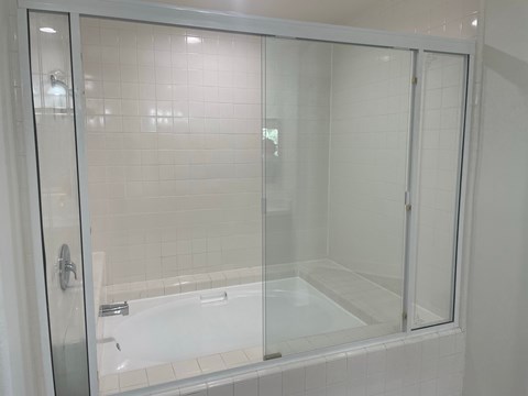 a bathroom with a shower and a bath tub