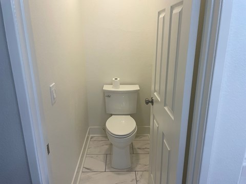 a bathroom with a toilet and a roll of toilet paper