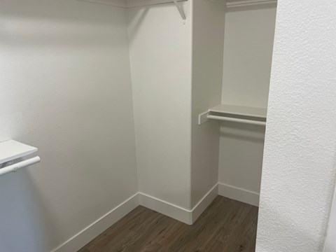 a small closet in a room with a wooden floor and white walls