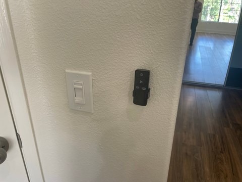 a wall with a remote control and a light switch on it