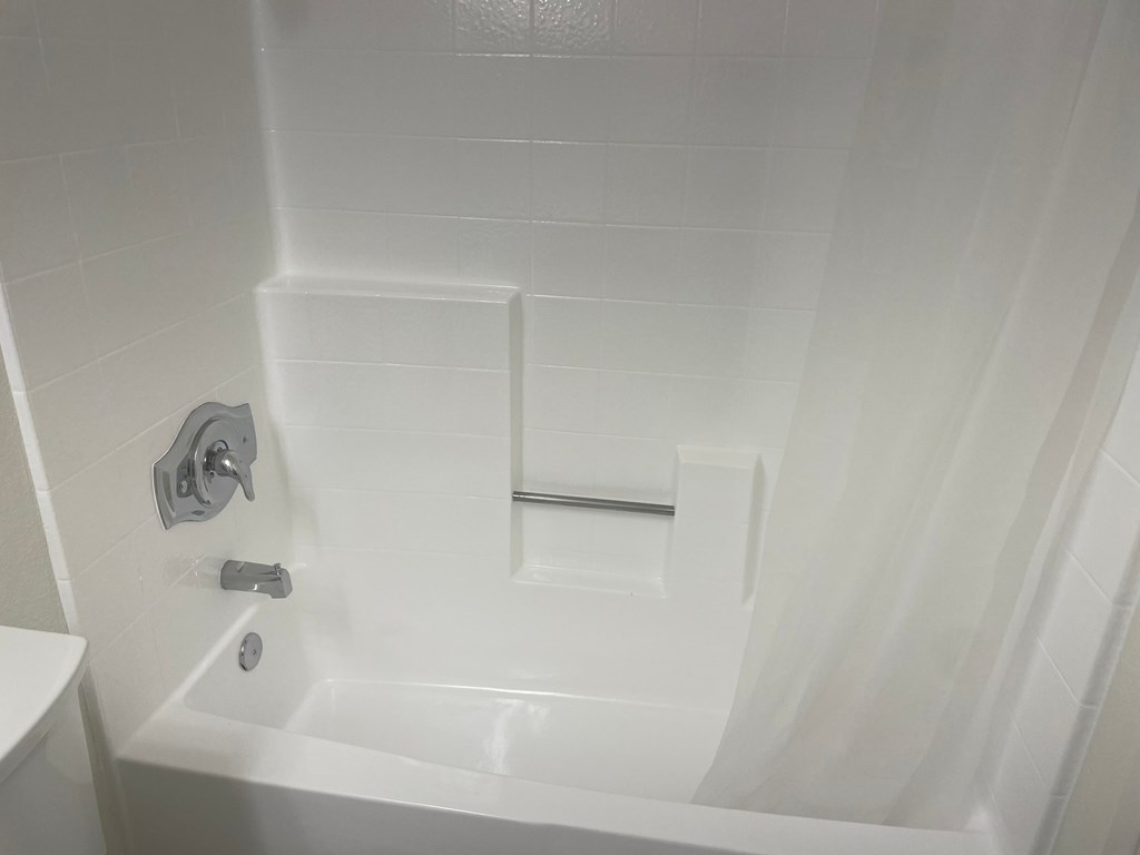 a white bathtub with a shower curtain in a bathroom