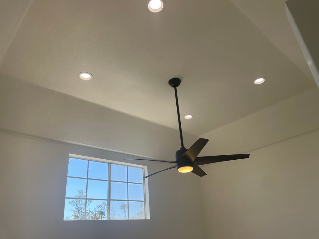 a view of the ceiling fan in a living room with a window