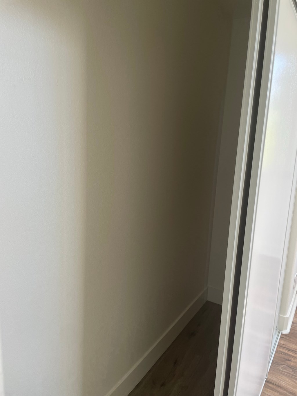 the corner of a room with white walls and a sliding door