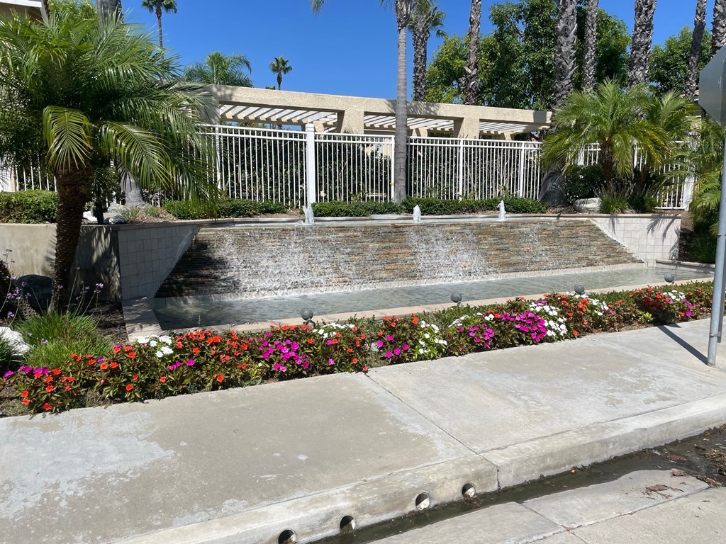 a fountain in front of a building with palm trees