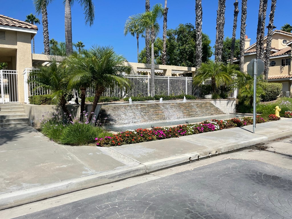 a fountain in the middle of a street with palm trees