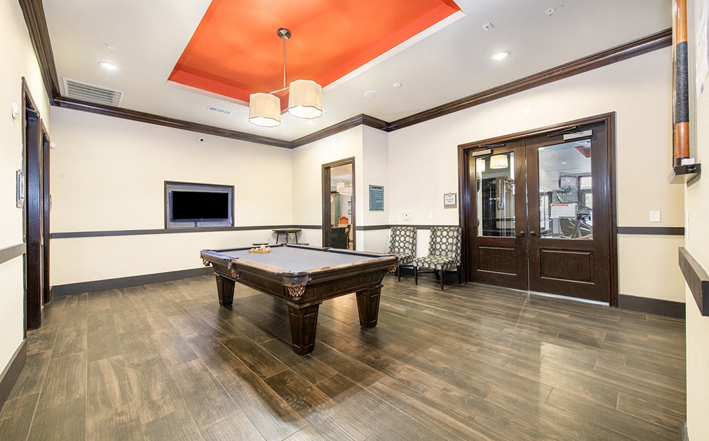 a billiards room with a pool table and a tv