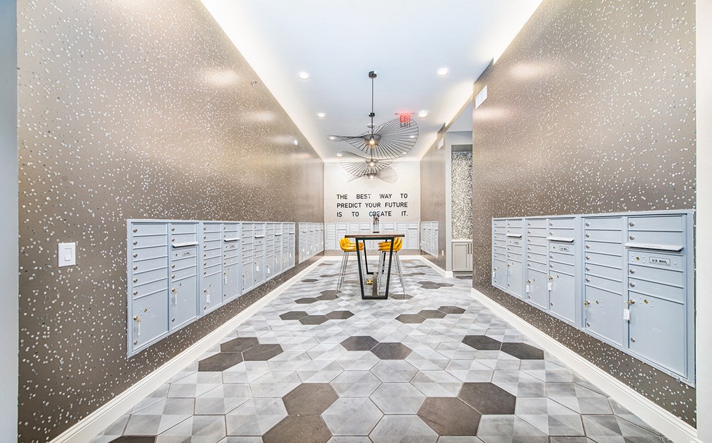 a locker room with rows of blue lockers and a table with a yellow chair