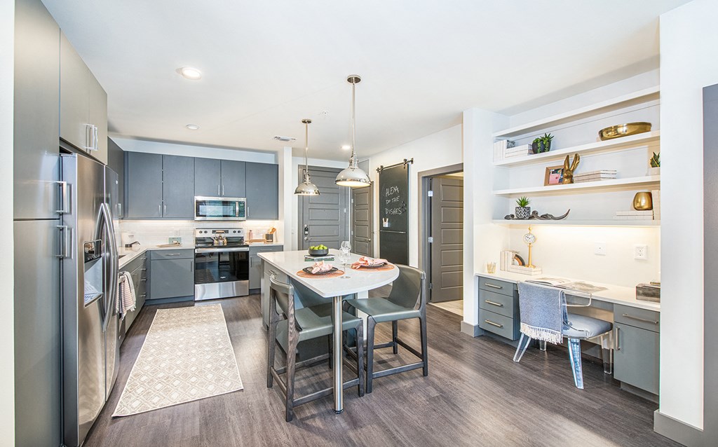 a kitchen with stainless steel appliances and a dining table