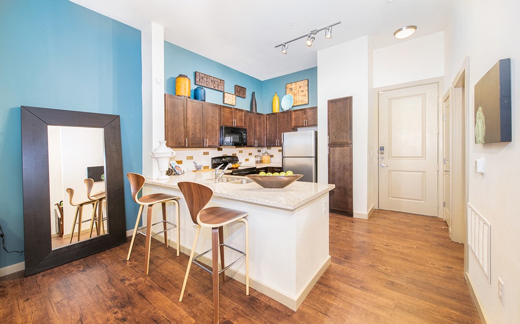 a kitchen with a bar and stools in a small apartment