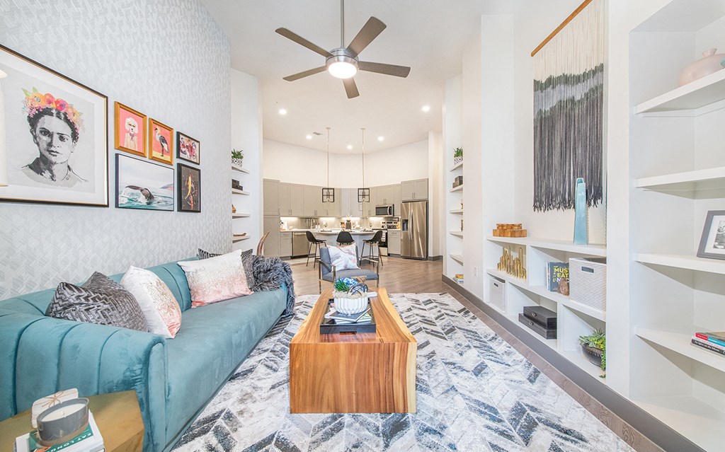 a living room with a blue couch and a ceiling fan