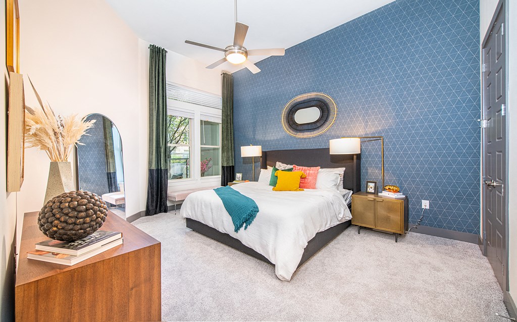 a blue and white bedroom with a bed and a ceiling fan