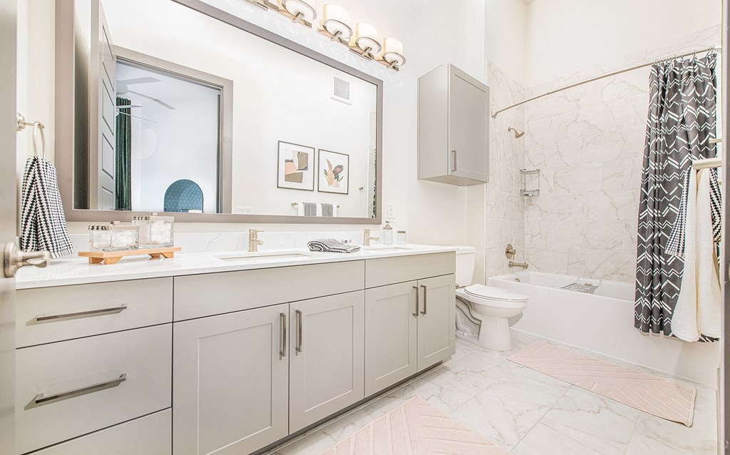 a bathroom with white cabinets and a sink and a toilet