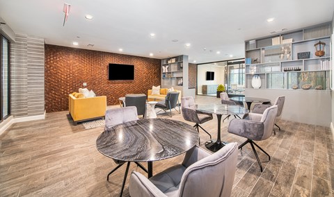 a lounge area with tables and chairs and a television