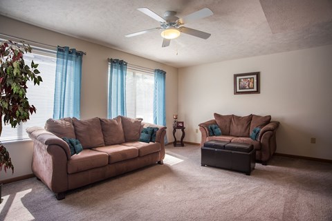 a living room with two couches and a ceiling fan