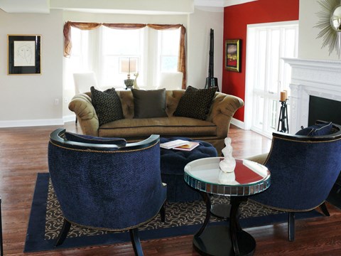 a living room with blue chairs and a couch and a fireplace