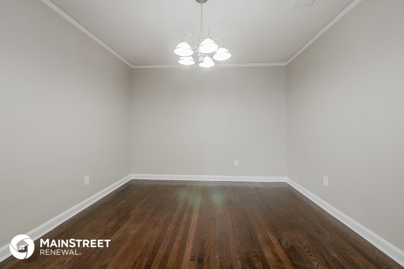 the interior of an empty room with wooden floors and white walls