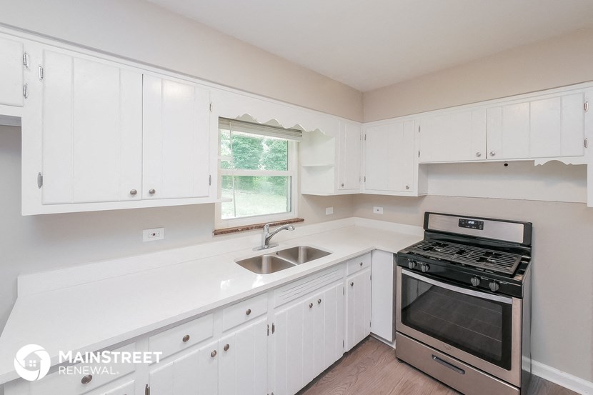 a white kitchen with stainless steel appliances and white cabinets