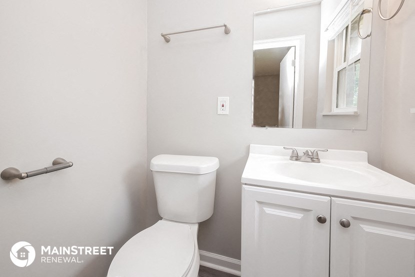 a bathroom with a sink toilet and a mirror
