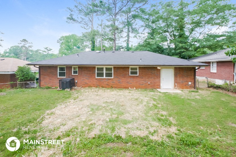 the front of a brick house with a yard and grass