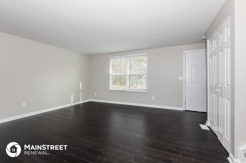 the living room of a house with a white door and a window