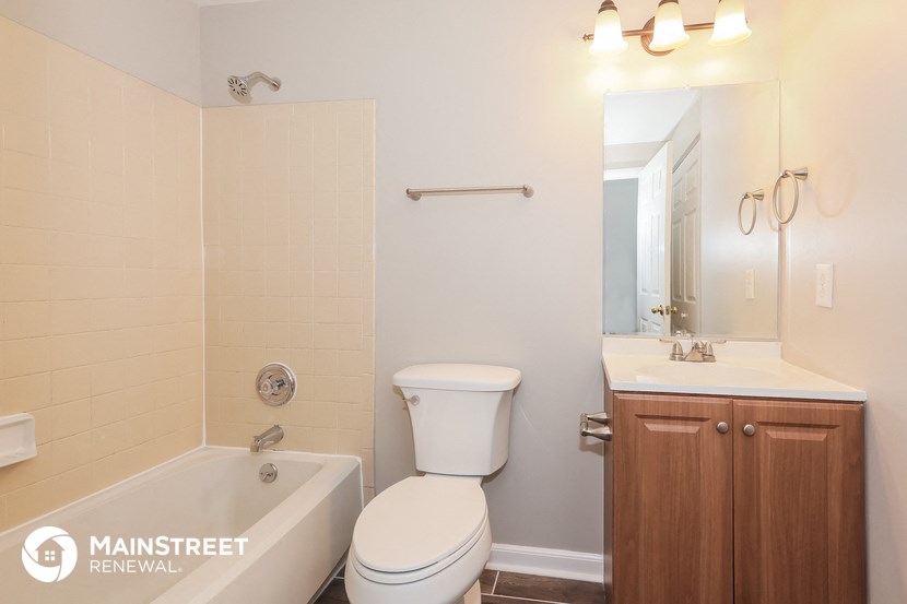 a bathroom with a toilet sink and tub and a mirror