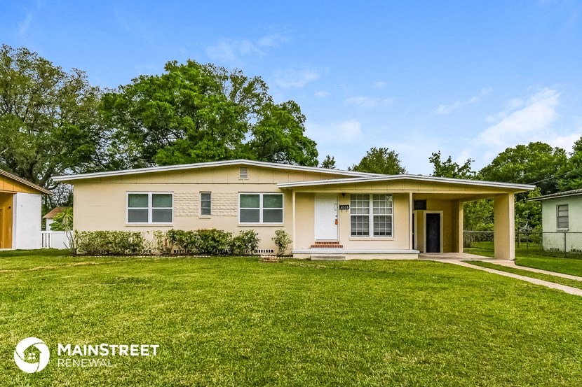 a beige house with a lawn in front of it
