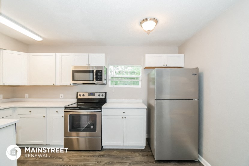 a kitchen with white cabinets and stainless steel appliances
