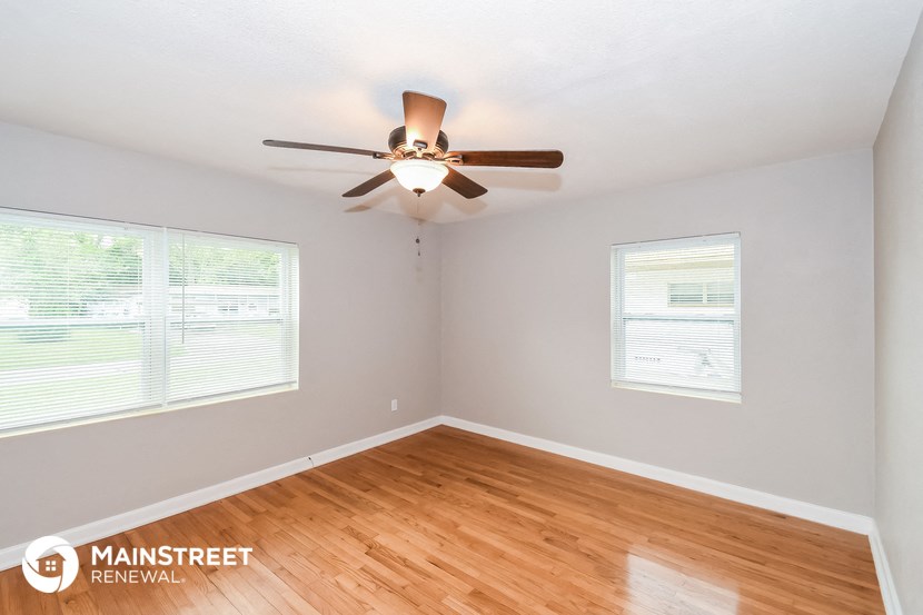 a living room with a ceiling fan and wood floors