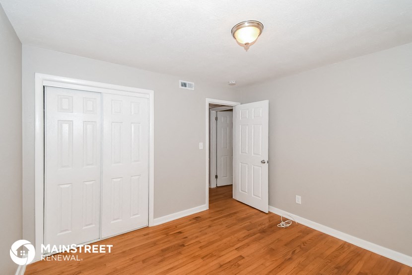 a bedroom with two closets and a door to a hallway