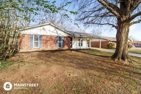 a small brick house with a tree in front of it