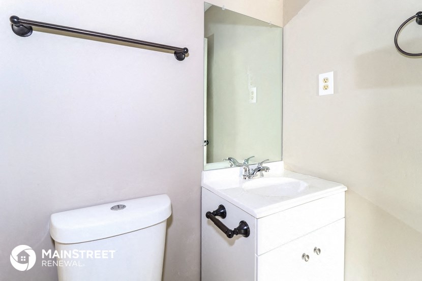 a bathroom with a mirror and a toilet and a sink