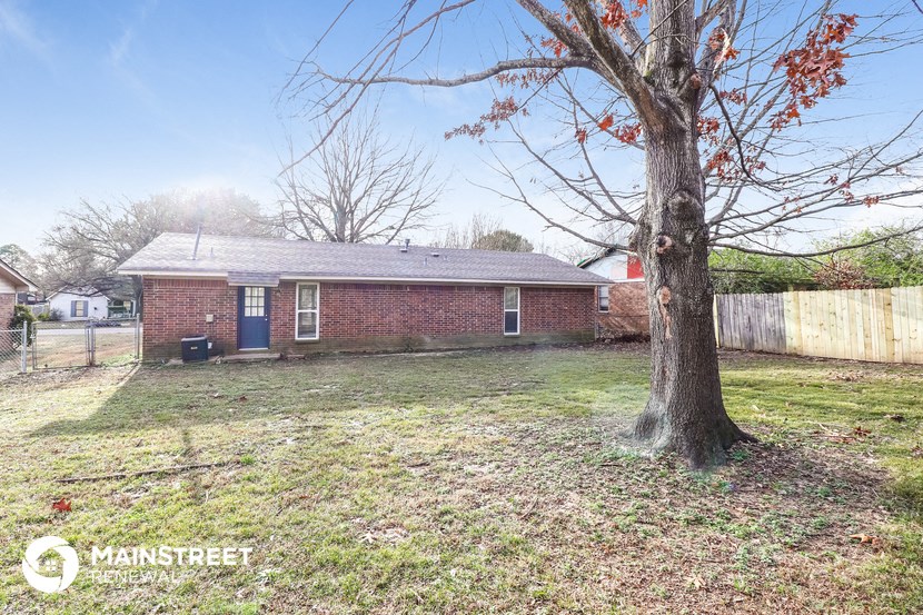 a small brick house with a tree in the yard