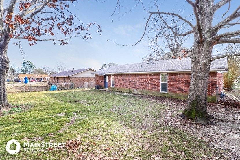 a brick house with a yard and a tree