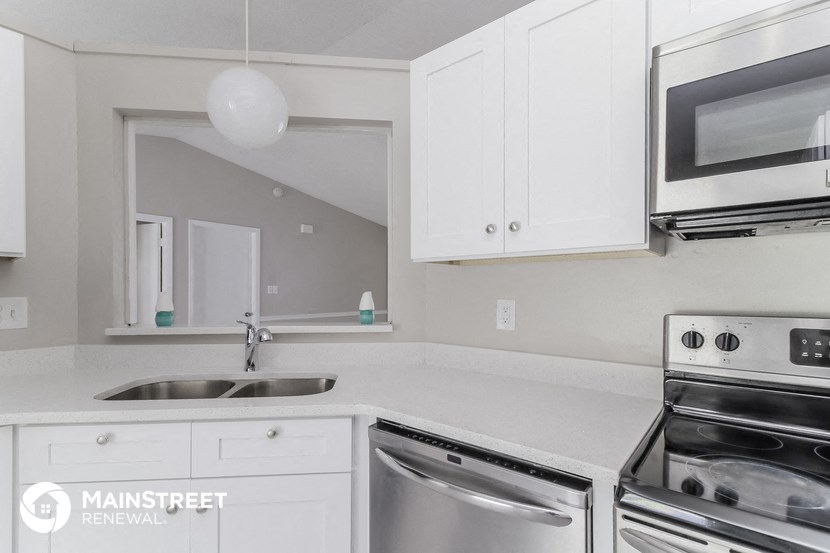 a white kitchen with stainless steel appliances and white cabinets