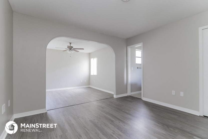 the living room and dining room with hardwood flooring and a ceiling fan