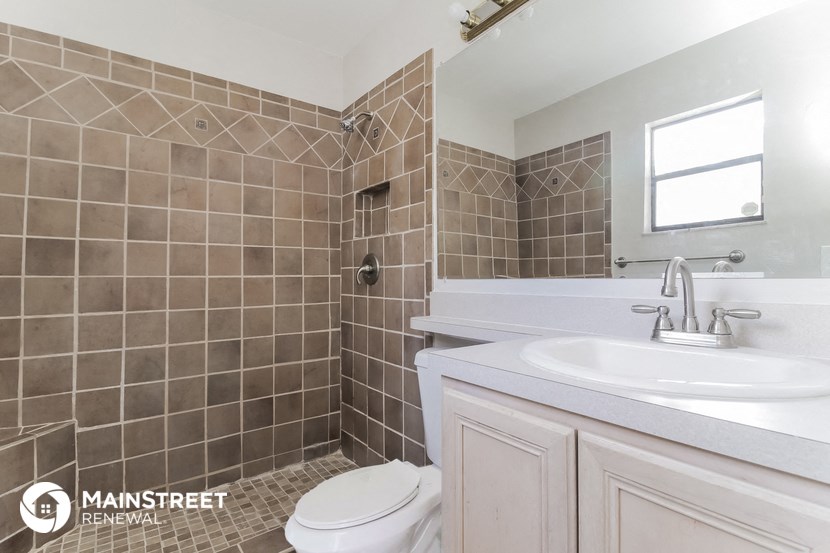 a tiled bathroom with a sink toilet and shower