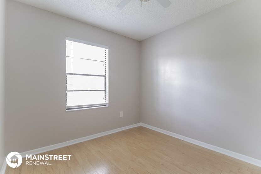 the interior of an empty room with wooden floors and a window