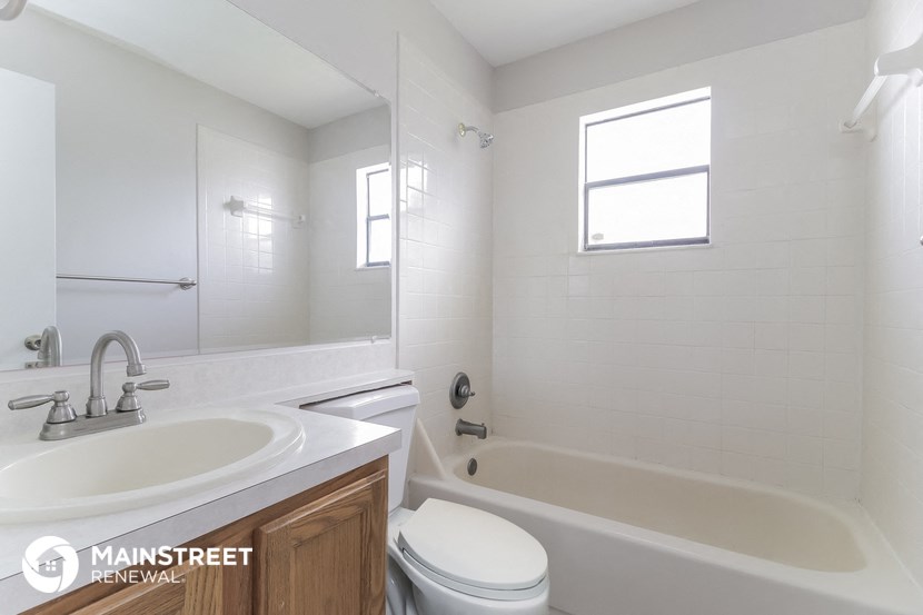 a bathroom with a sink toilet and tub and a mirror