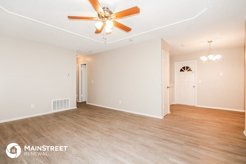 the living room and dining room with wood flooring and ceiling fan