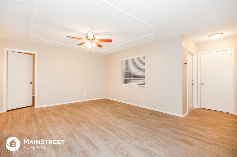 a living room with a ceiling fan and wood flooring