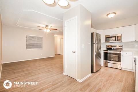 a kitchen with white cabinets and a stainless steel refrigerator