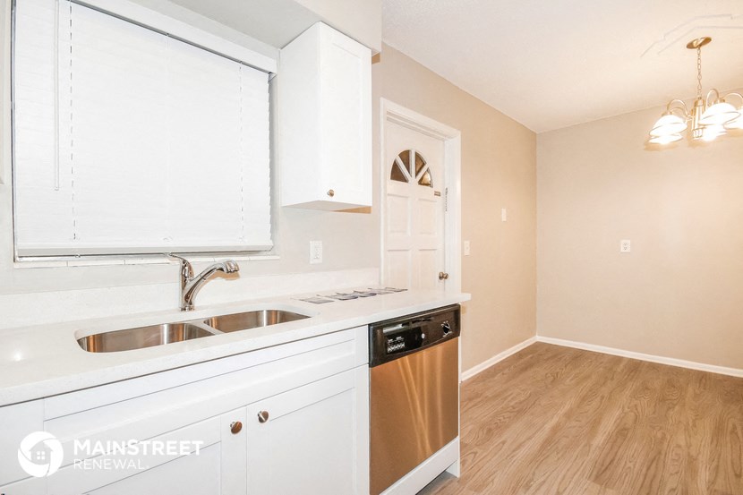 a kitchen with white cabinets and a sink and a dishwasher