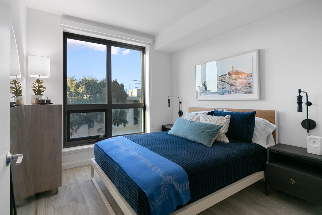 a bedroom with a bed and a large window