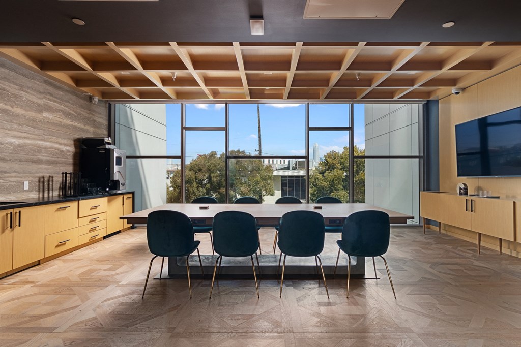 a conference room with a long table and chairs and a large window