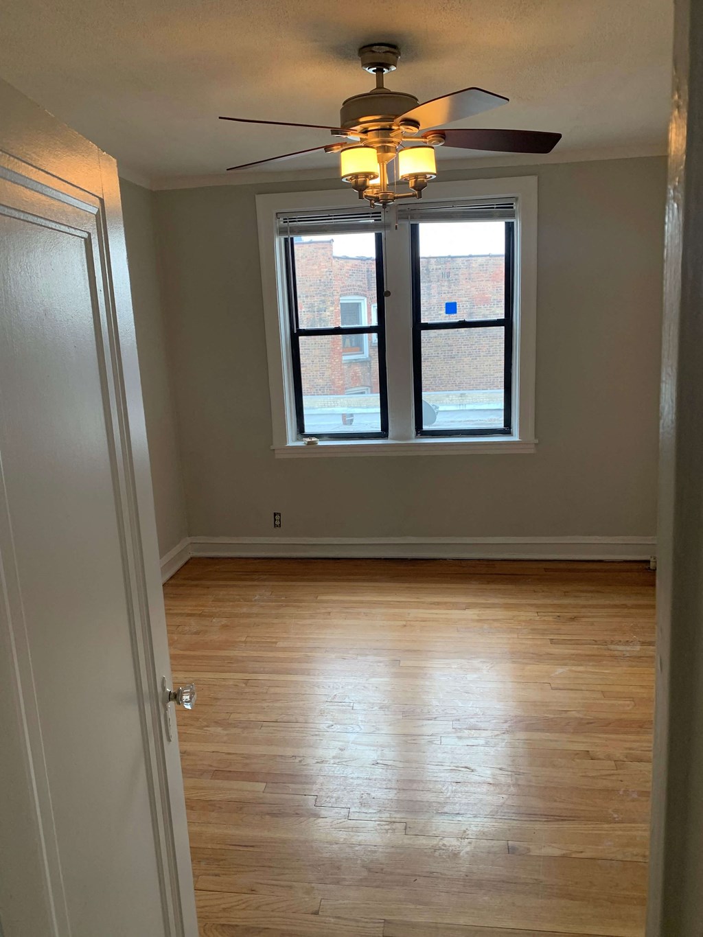 an empty room with a ceiling fan and a window