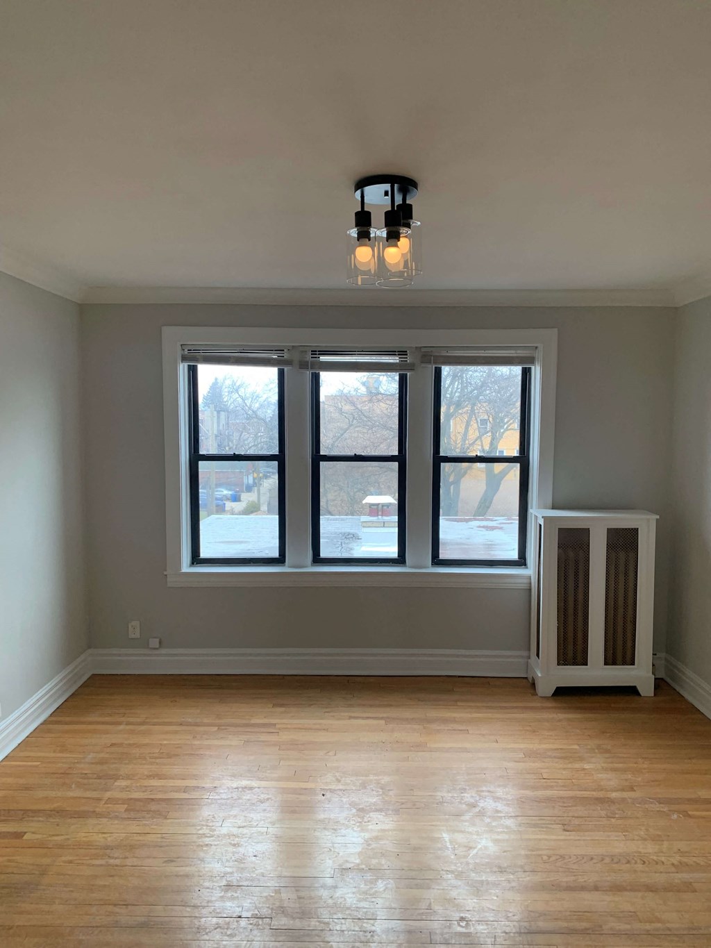 a living room with a large window and a wooden floor