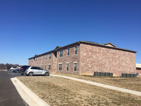 a large brick building with cars parked in front of it