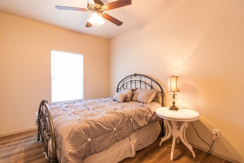 a bedroom with a bed and a ceiling fan