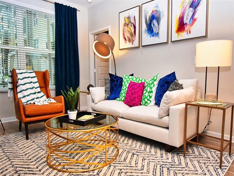 a living room with a white couch and colorful pillows