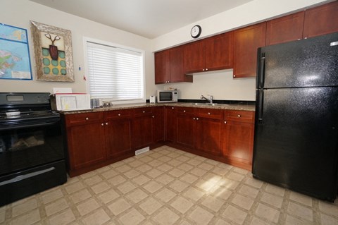 a kitchen with black appliances and wooden cabinets